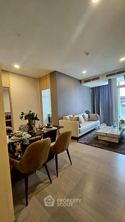 Modern living room with elegant dining area and cozy seating, featuring contemporary decor and natural light.