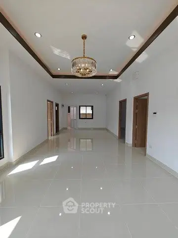 Spacious modern living room with elegant chandelier and glossy tiled flooring