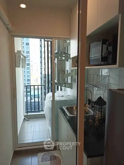 Compact kitchen with balcony view in modern apartment