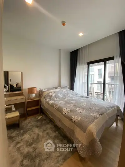 Cozy bedroom with modern decor and large window offering natural light