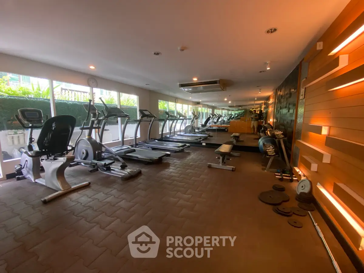 Modern gym with state-of-the-art equipment and ambient lighting in a luxury residential complex.