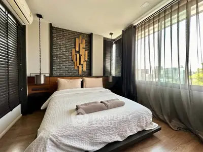 Modern bedroom with stylish decor and large windows offering natural light.