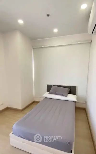 Minimalist bedroom with single bed and modern lighting