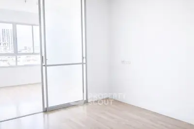 Bright minimalist room with sliding glass door and large window view.