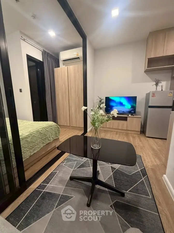 Modern living room with stylish decor and open layout, featuring a cozy bedroom view and sleek furniture.