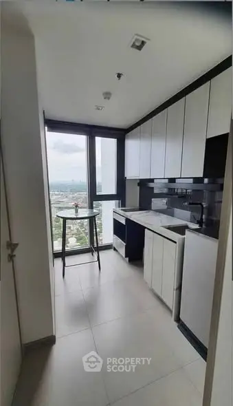 Modern kitchen with sleek cabinets and stunning city view from window.