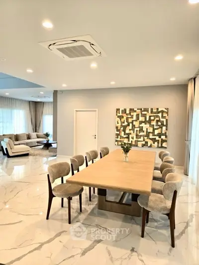 Luxurious open-plan dining and living area with modern decor and elegant marble flooring.