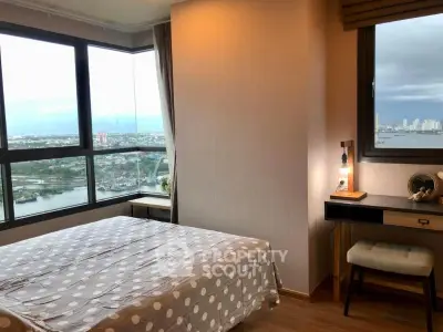 Modern bedroom with stunning city and river view from large windows.