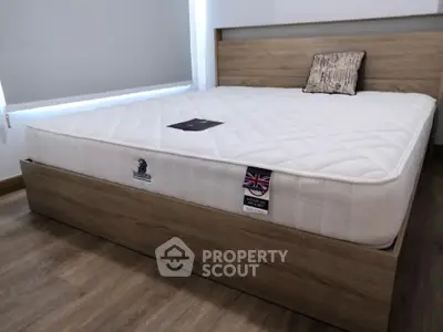 Spacious bedroom with modern wooden bed frame and comfortable mattress
