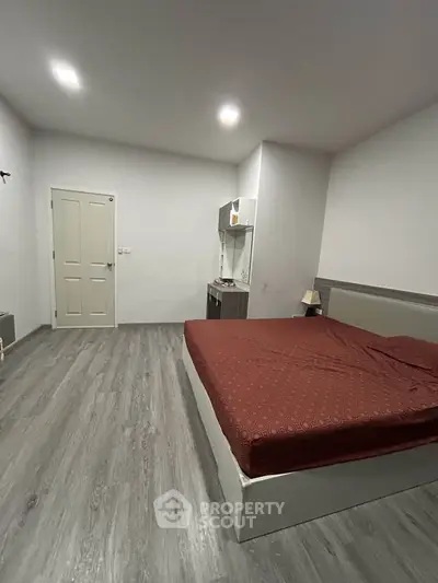 Spacious bedroom with modern flooring and minimalist design