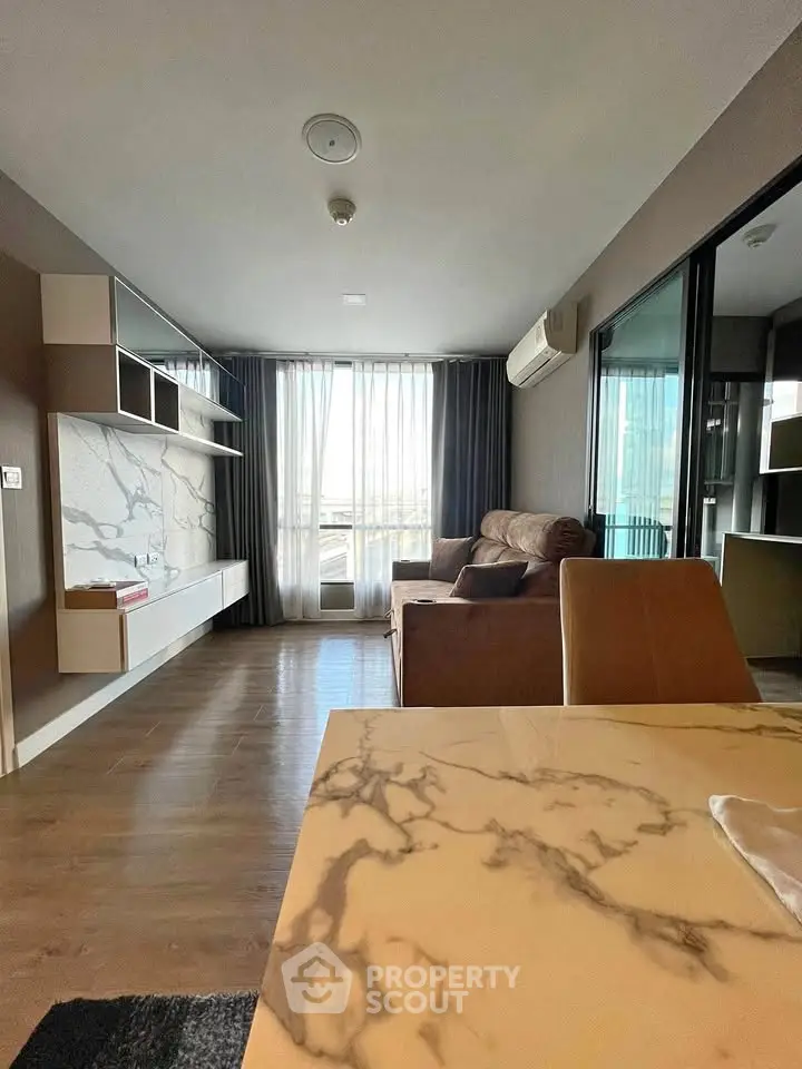 Modern living room with marble accents and large windows in a stylish apartment.