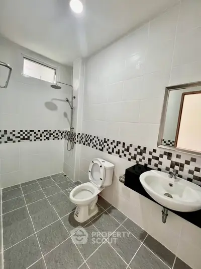 Modern bathroom with sleek tiles and contemporary fixtures in a stylish real estate property.