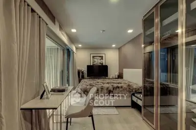 Luxurious bedroom with modern decor and mirrored wardrobe in upscale apartment.