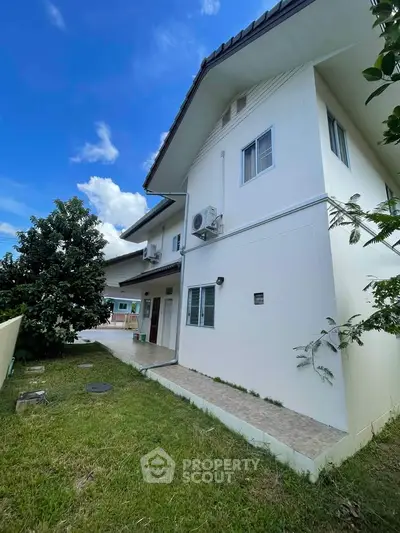 Charming two-story house with lush garden and modern exterior design, perfect for family living.