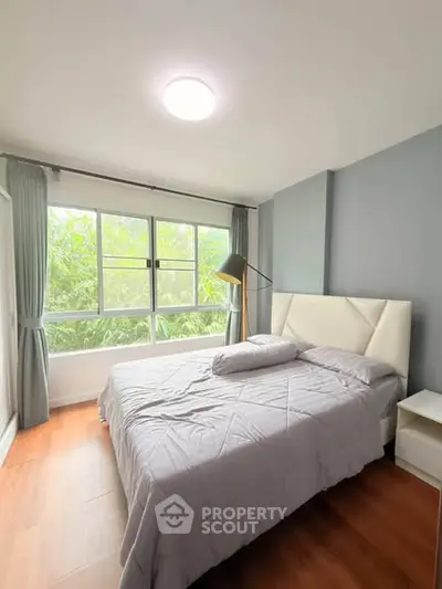 Bright and cozy bedroom with large window and modern decor