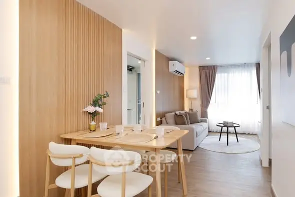 Modern living room with dining area, featuring wooden accents and bright natural lighting.