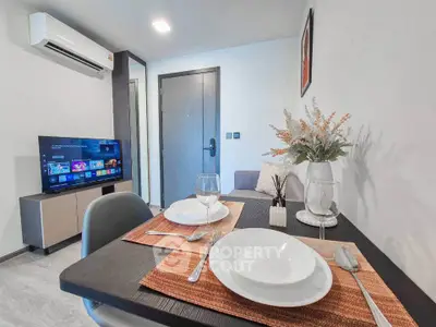 Modern living room with dining area, TV, and air conditioning in a stylish apartment.