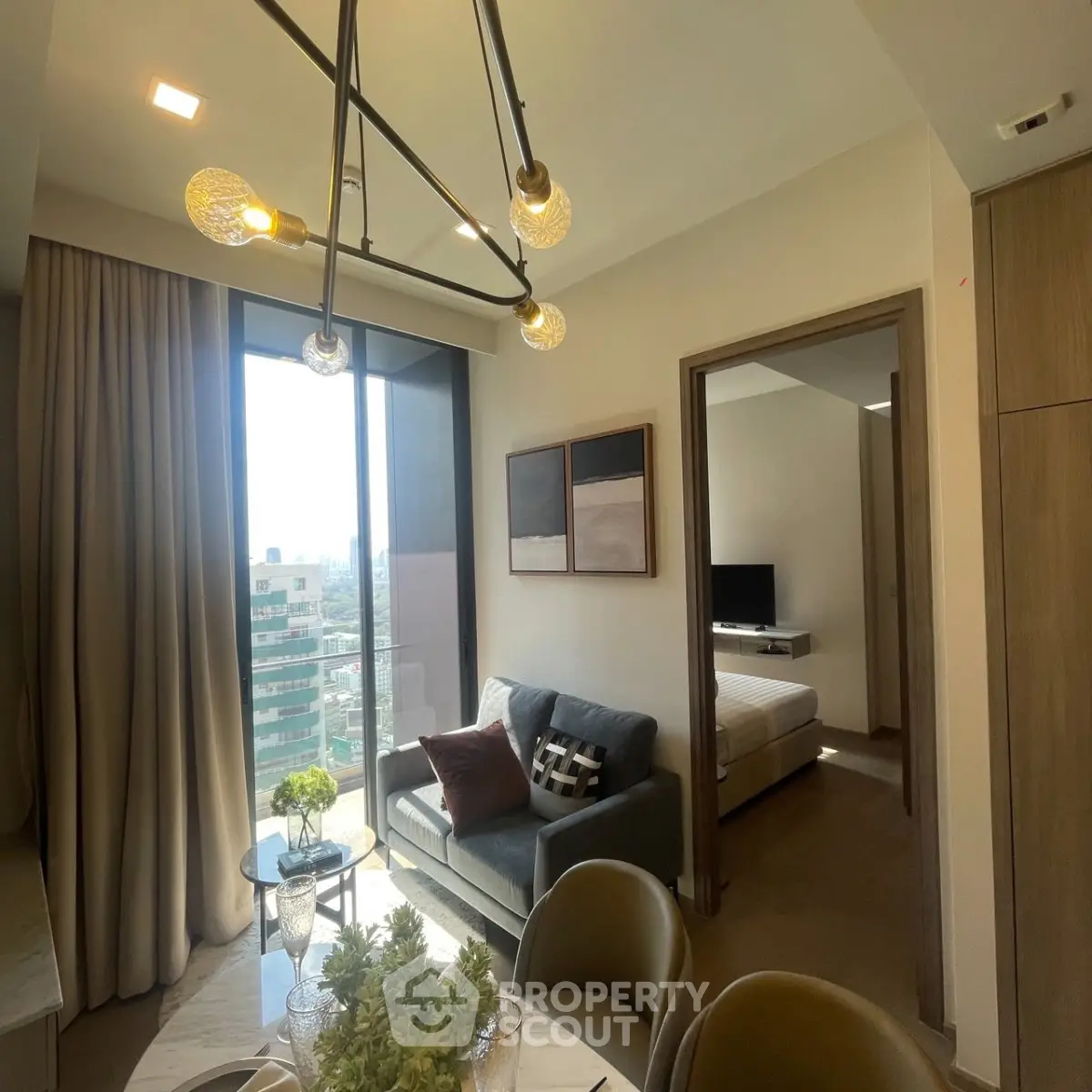 Modern apartment interior with stylish living room and bedroom, featuring large windows and elegant lighting.