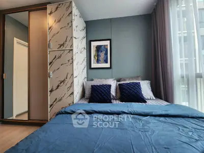 Elegant bedroom with luxurious blue bedding, stylish marble accent wall, and modern wooden wardrobe, perfect for restful nights and chic living.