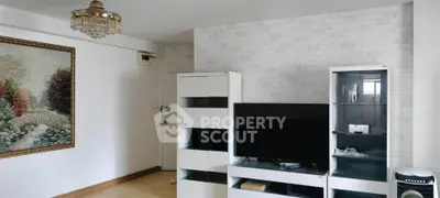 Spacious living room with modern entertainment center and elegant chandelier