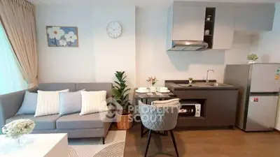 Modern open-layout kitchen and living room with stylish decor and cozy seating area.