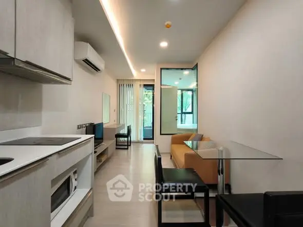 Modern living room with open kitchen and stylish furniture in a cozy apartment.