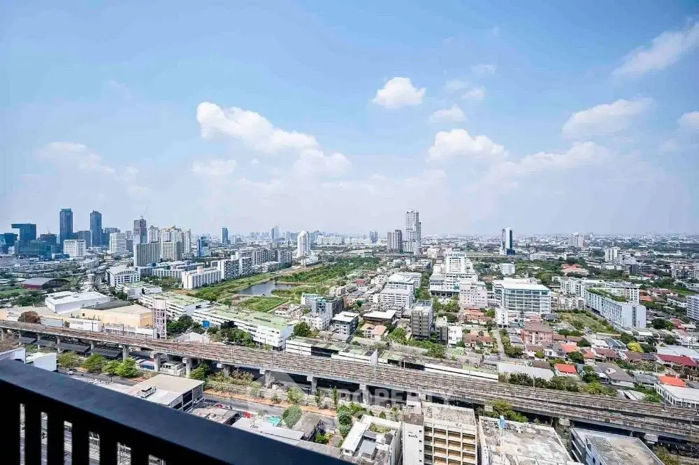 Stunning cityscape view from high-rise balcony overlooking urban skyline and railway.