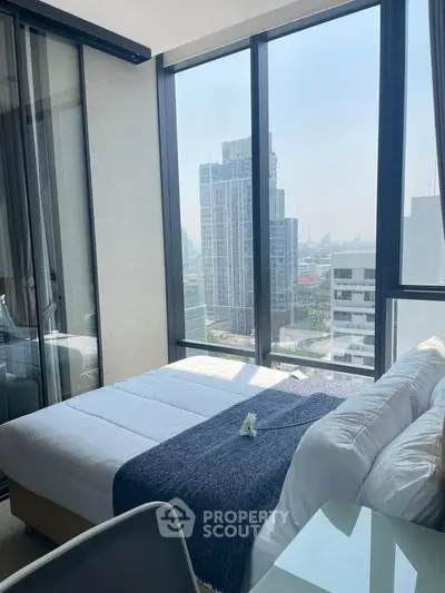 Modern bedroom with floor-to-ceiling windows offering stunning city views