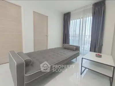 Modern living room with sleek gray sofa and natural light