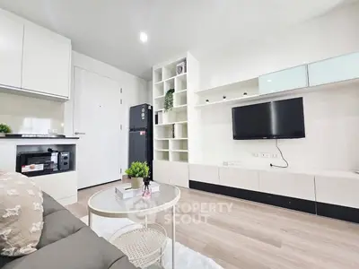 Modern living room with sleek furniture and built-in storage, featuring a wall-mounted TV.