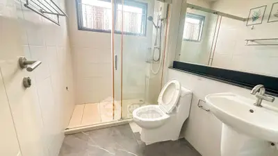 Modern bathroom with glass shower, sleek fixtures, and natural light.