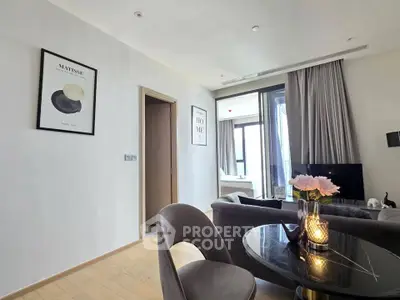 Modern living room with elegant decor and natural light, featuring stylish furniture and art pieces.
