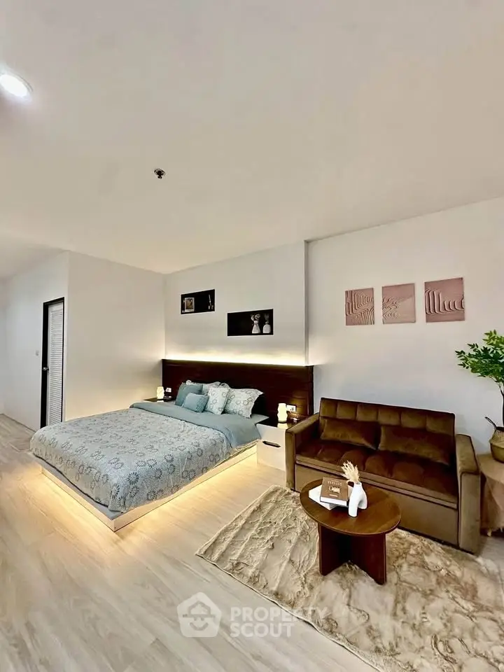Spacious modern bedroom with cozy seating area and stylish decor