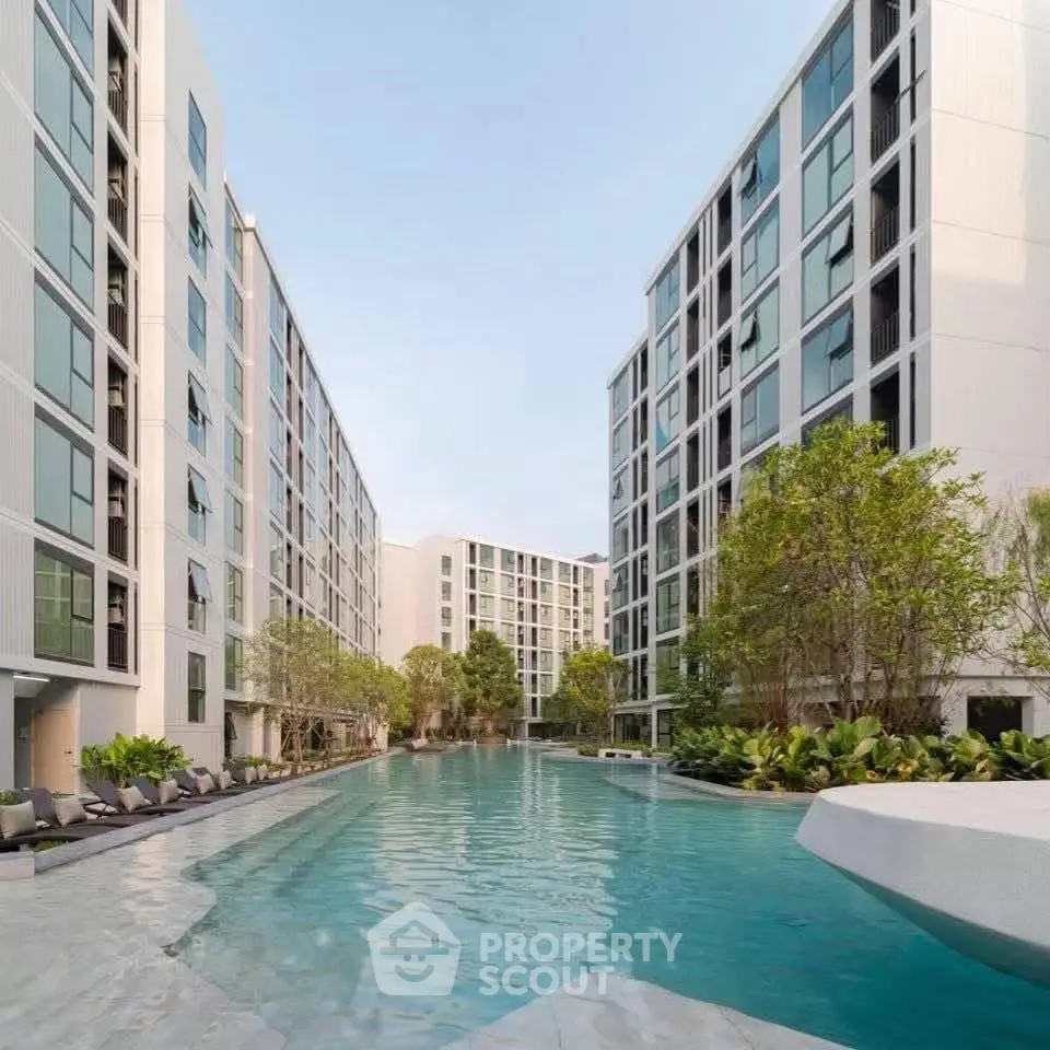 Luxurious modern apartment complex with stunning pool and lush greenery.