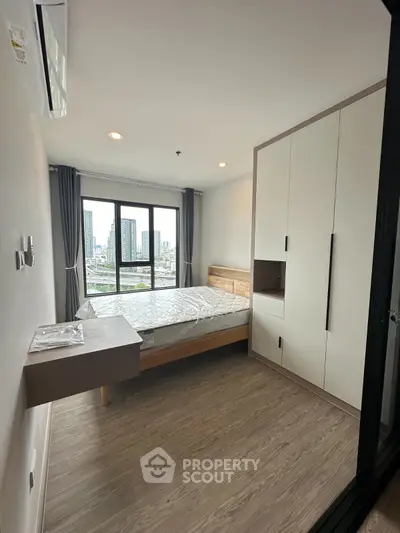 Modern bedroom with city view, featuring sleek wardrobe and stylish bed in a high-rise apartment.