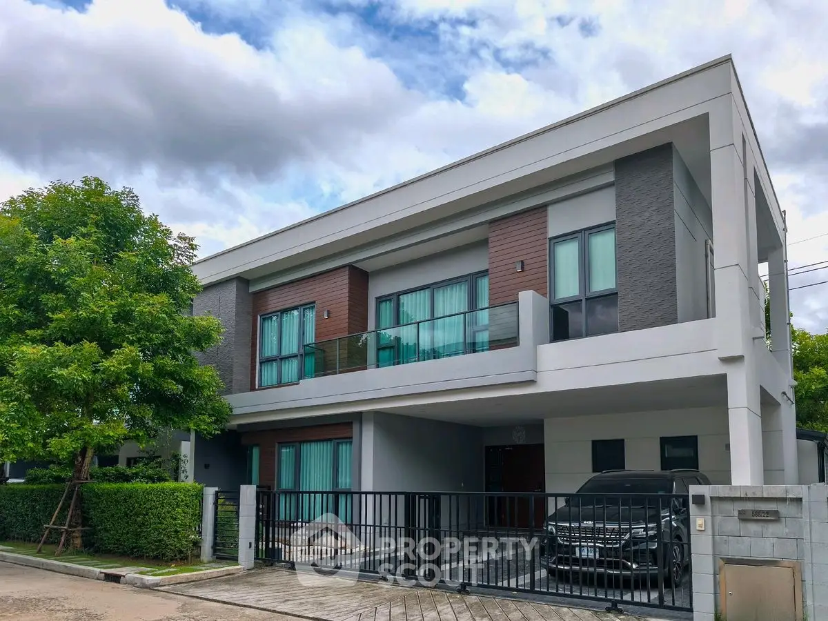 Modern two-story house with sleek design and spacious balcony in a suburban neighborhood.