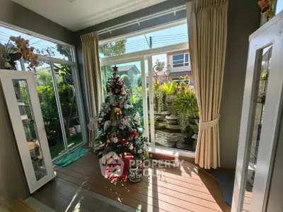 Charming living room with Christmas tree and garden view, perfect for holiday gatherings.