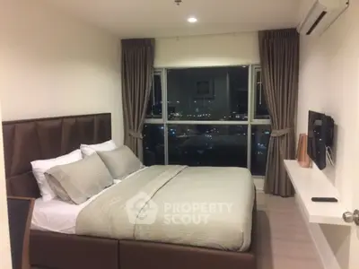 Modern bedroom with city view, featuring cozy bed and wall-mounted TV.