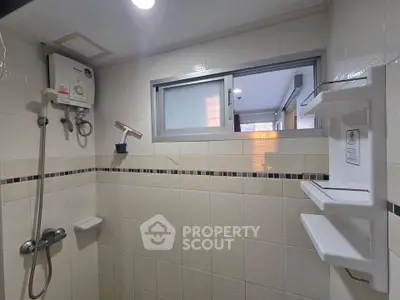 Modern bathroom with shower and water heater in a tiled interior
