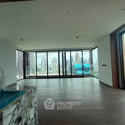 Spacious modern living room with panoramic city views and elegant wooden flooring.