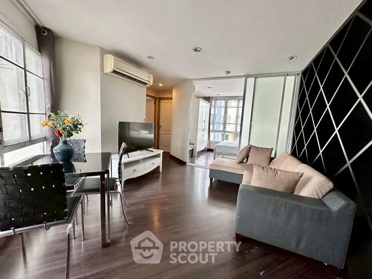 Modern living room with sleek furniture and large windows in a stylish apartment.