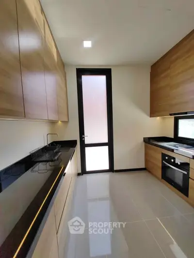 Modern kitchen with sleek wooden cabinets and built-in oven