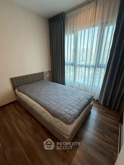 Modern bedroom with large window and stylish decor in urban apartment