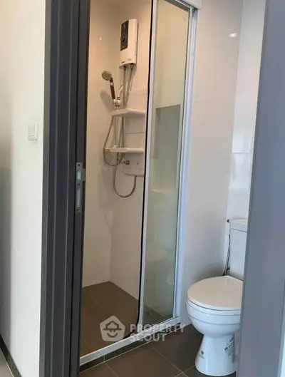Compact modern bathroom with shower and toilet in sleek design.
