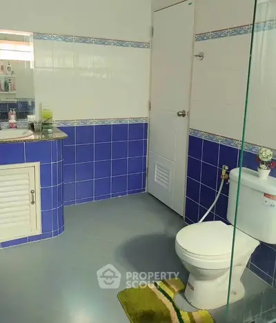 Spacious bathroom with blue tile accents and modern fixtures