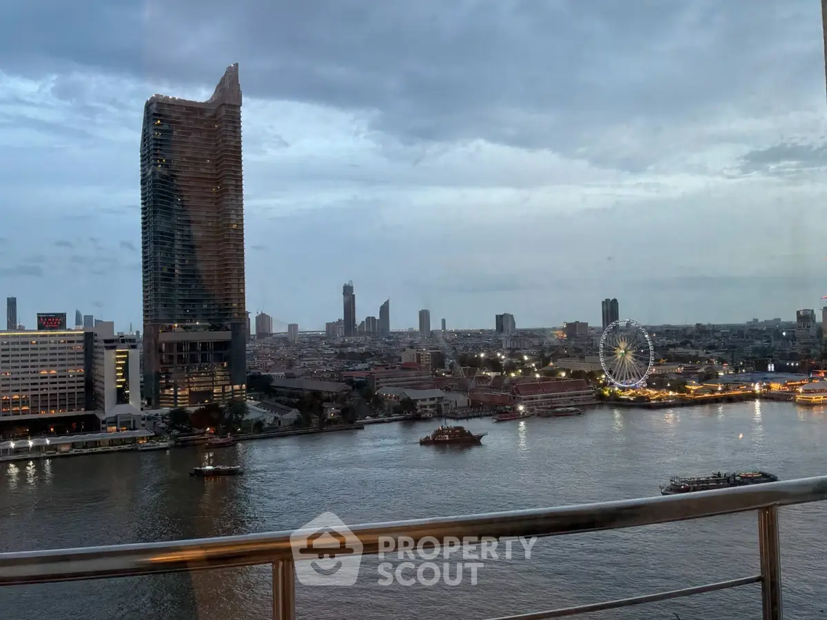 Stunning riverfront view from a high-rise balcony overlooking city skyline and ferris wheel at dusk.