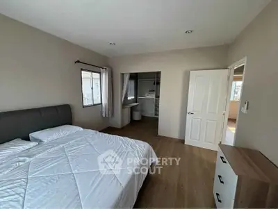 Spacious bedroom with walk-in closet and natural light, perfect for comfortable living.