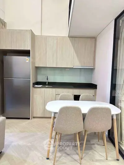 Modern kitchen with sleek cabinetry and dining area in a stylish apartment