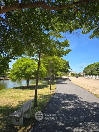Scenic park pathway with lush greenery and serene water view