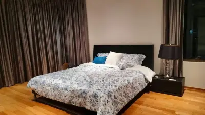 Spacious bedroom with elegant decor and large bed in modern apartment.